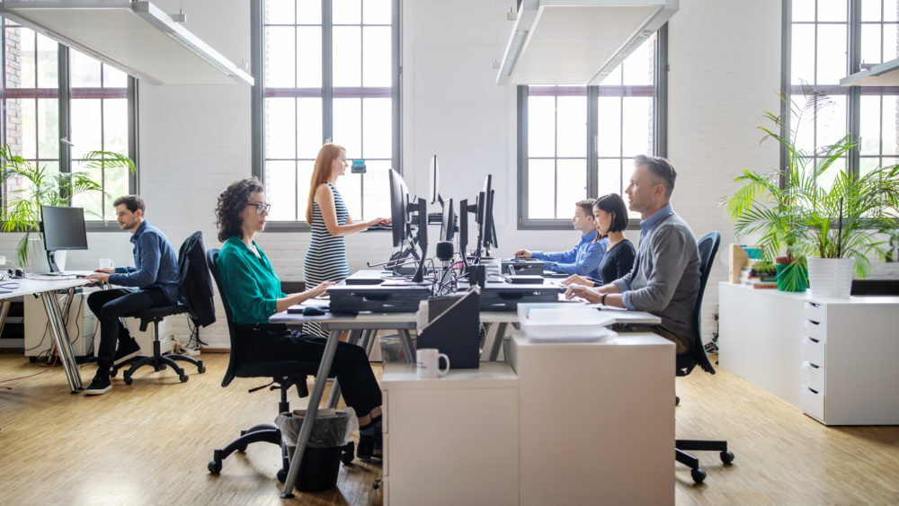 Business people working at a modern office Business people at their desks in a busy, open plan office. Startup business people working at a modern office.