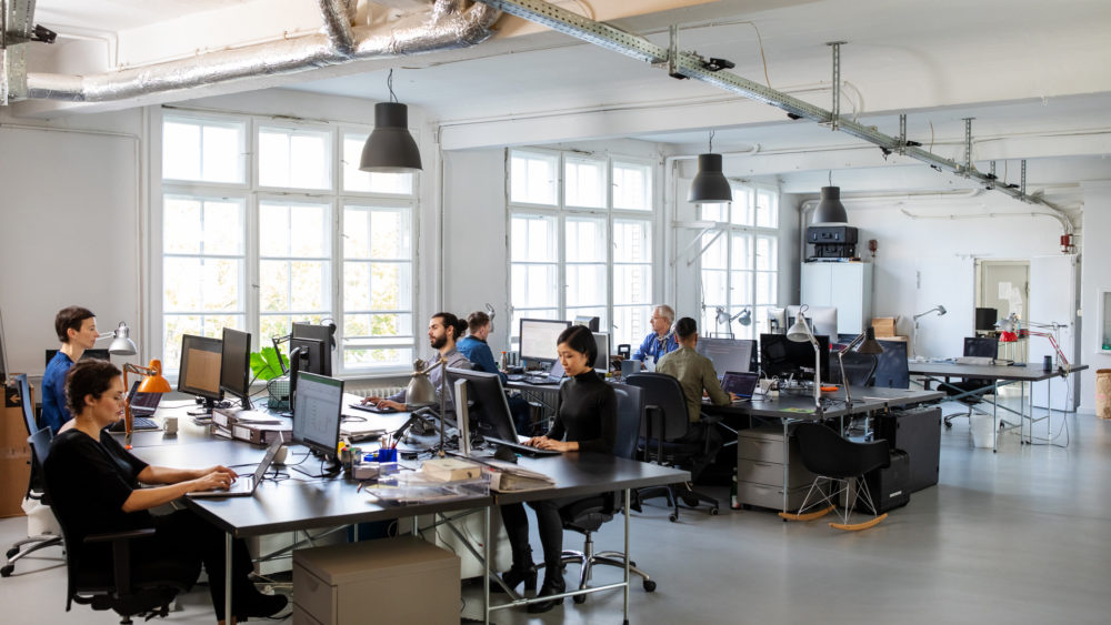 Busy modern open plan office with staff Casually dressed workers in a busy open plan office. Business people working at a modern office.